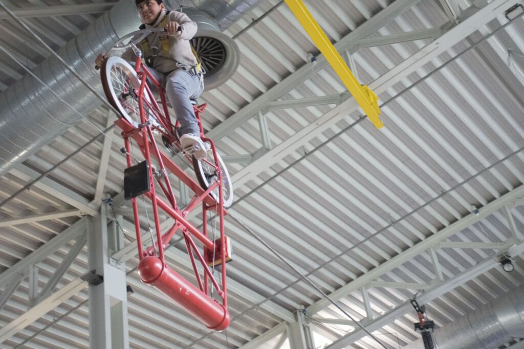 Jongen fietst op koord in Technopolis met bescherming.