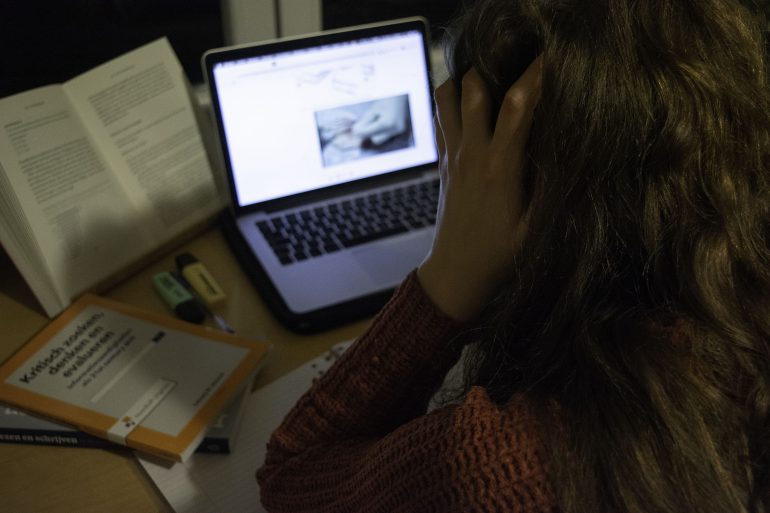 Studente zit met handen in het haar een online les te volgen