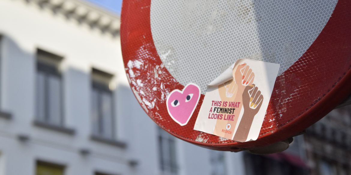 Feministische sticker op een verkeersbord