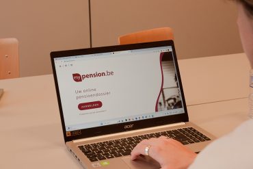 Een meneer is op zijn laptop zijn pensioen online aan te vragen