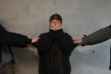 Kind staat tussen haar gescheiden ouders.