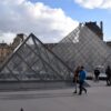 Foto van het Louvre in Parijs, twee glazen piramides, voorbijgangers