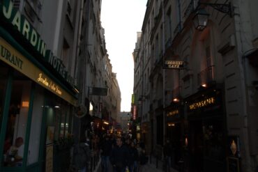 Straat in Parijs met horeca gelegenheden in de avond met lichtjes