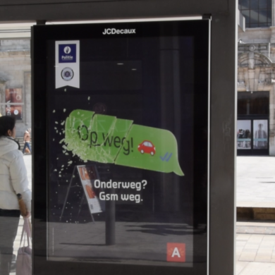 campagneposter tegen gsm gebruik achter het stuur "Onderweg? Gsm weg."