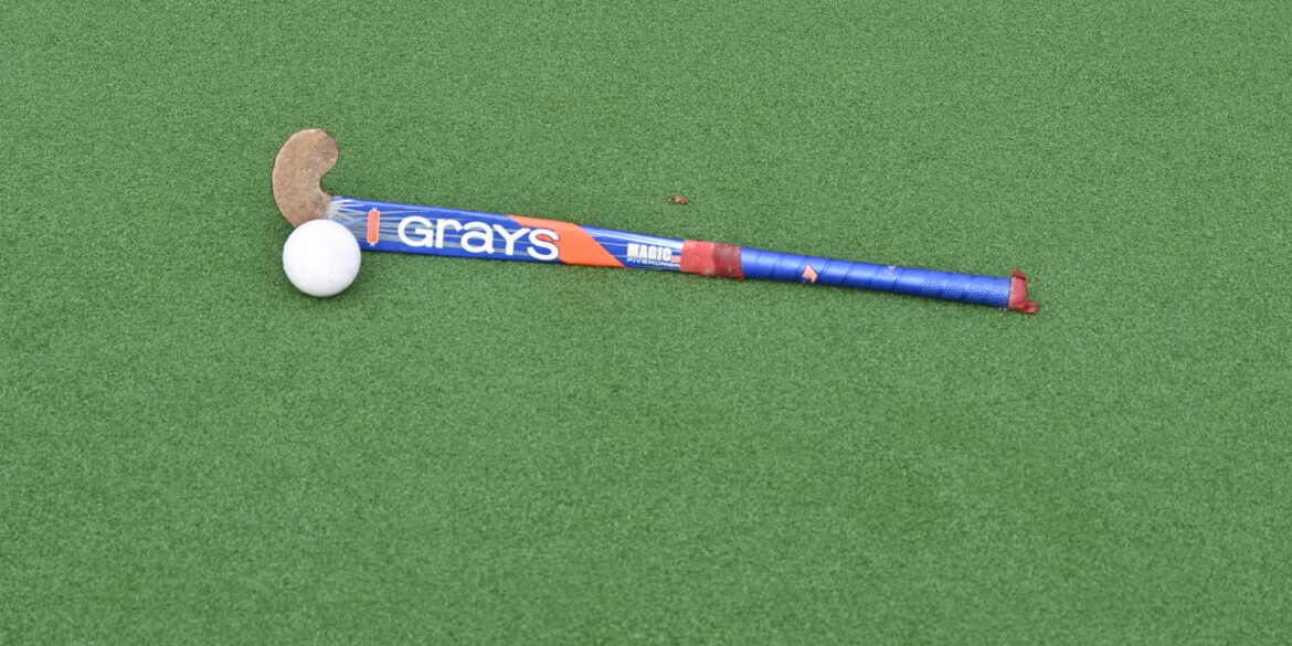 Hockeystick en bal op waterveld