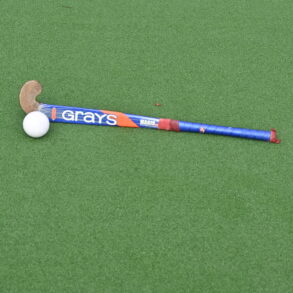 Hockeystick en bal op waterveld