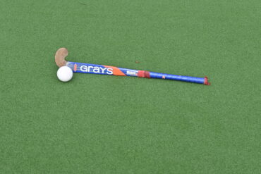 Hockeystick en bal op waterveld