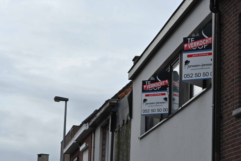 Immoborden met 'te Koop' hangen aan raam van woningen