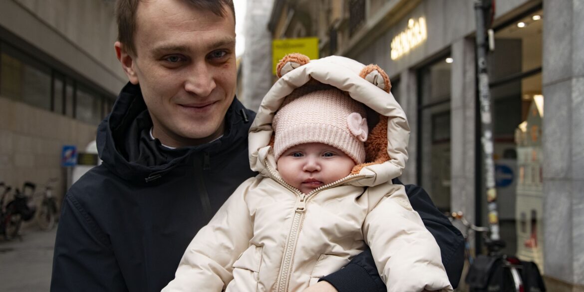 Vader met baby op zijn arm in winterkledij