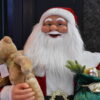 Kerstmanpop met teddybeer en zak in zijn handen