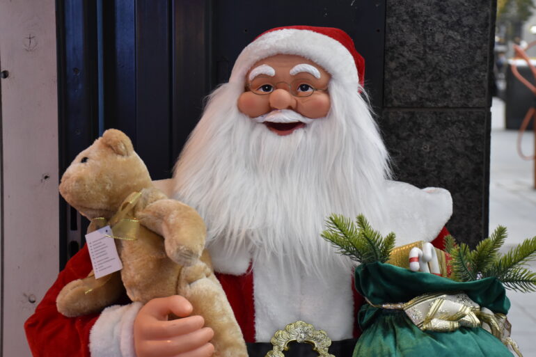 Kerstmanpop met teddybeer en zak in zijn handen