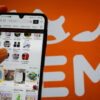 Iemand is op hen telefoon aan het surfen op de app van de Chinese online webshop Shein.