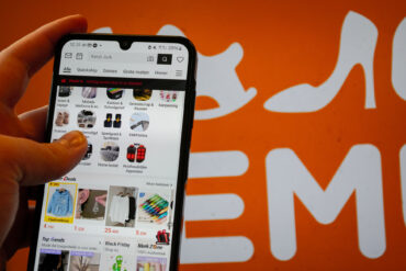 Iemand is op hen telefoon aan het surfen op de app van de Chinese online webshop Shein.