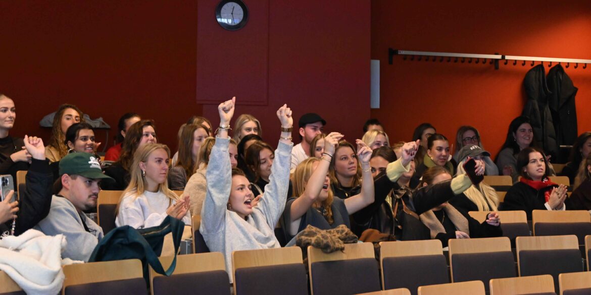 Foto van juichende studenten in een aula