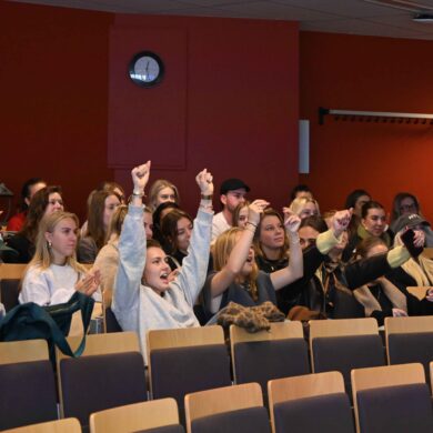 Foto van juichende studenten in een aula