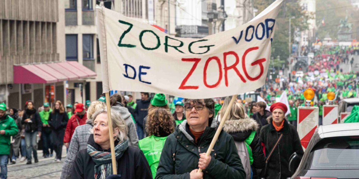 Mensen lopen door Brusselse straten met een spandoek