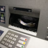 Er liggen geldbriefjes in de gleuf van een bankautomaat.