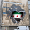 Syrische vlag in een krater van een gebouw (meistraat)