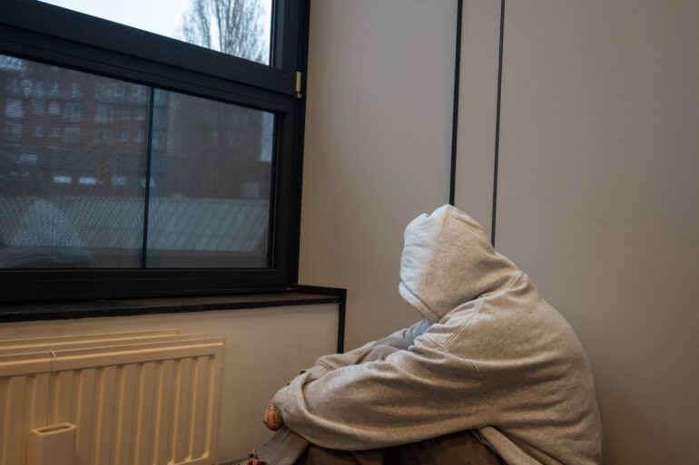 Jongere zit in een hoekje omdat ze moeite heeft met haar zelfbeeld.