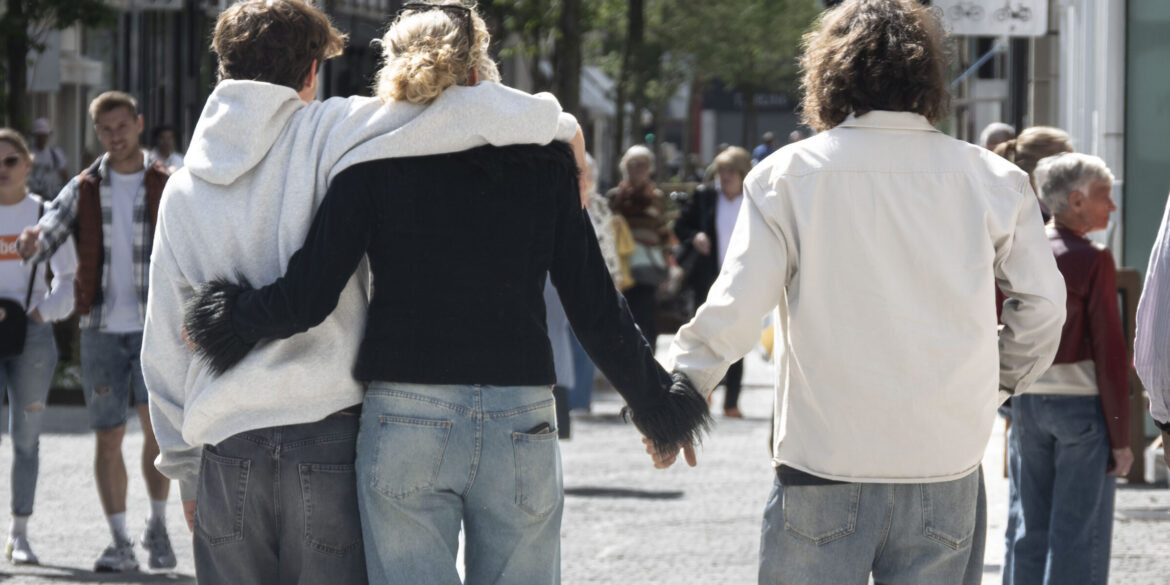Illustratie van een open relatie; een koppel links en de vrouw geeft een hand aan een derde persoon