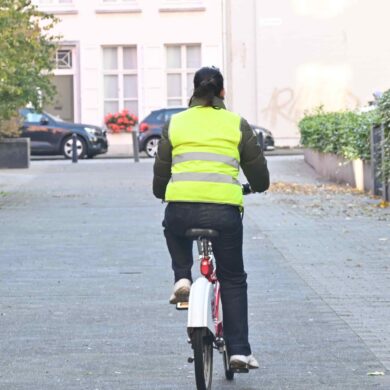 Een fietser met een fluohesje in het verkeer