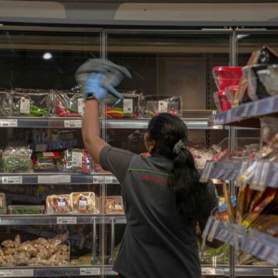 werknemer in een supermarkt dat ruiten poetst