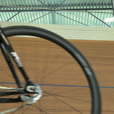 Wiel van fiets op baanwielrenbaan