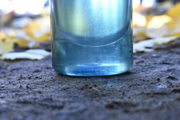 Onderkant van waterfles op donkere aarde