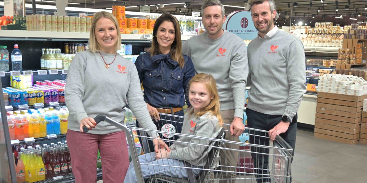 Groepsfoto van organisatoren van Walk For Alice. Zij zorgden voor de nieuwe winkelkar voor gehandicapte kinderen.