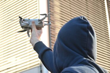 Man met kap houdt drone vast