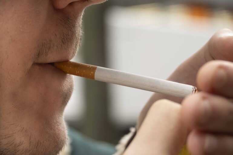 Man steekt sigaret op
