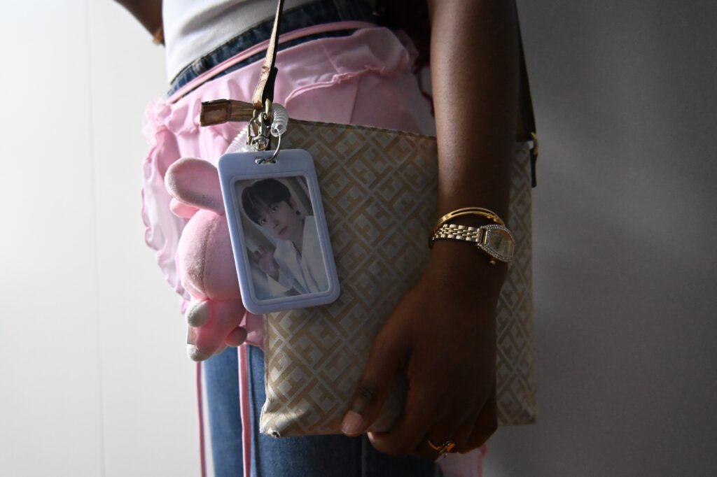 Een fan vertrekt naar een K-pop evenement met accessoires en fotokaarten.