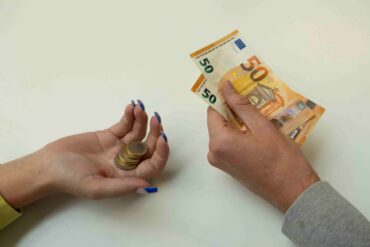 vrouwelijk hand met minder geld dan het mannelijk hand